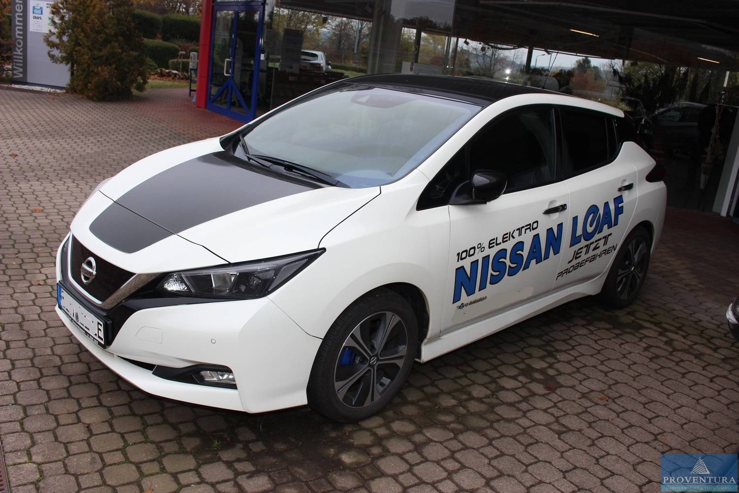 NISSAN-Autohaus 1x Nissan Leaf Elektro, 3x Pulsar, 2x Qasqai, Radlader ATLAS, Ersatzteile, Werkzeuge, Hebebühnen, Reifenregale, Container etc.